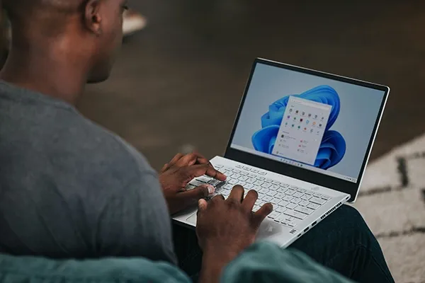 Man typing on laptop on his knees