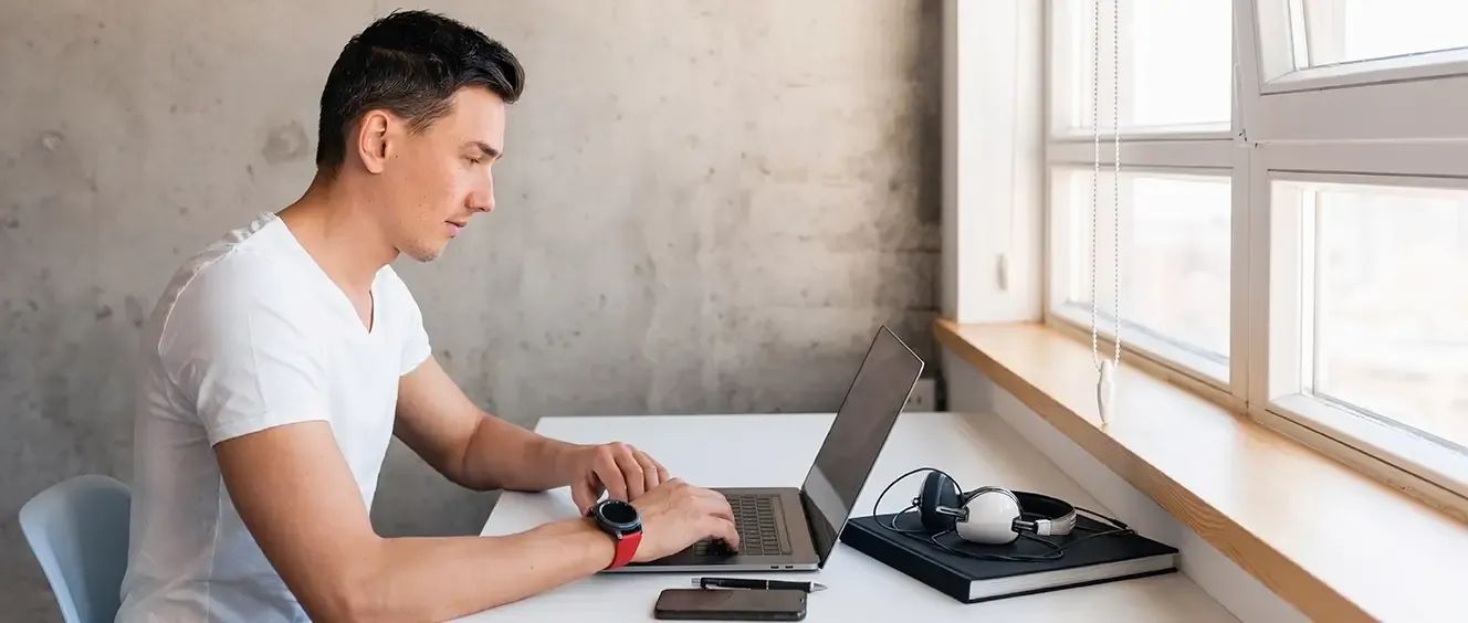 Man sitting at desk using laptop