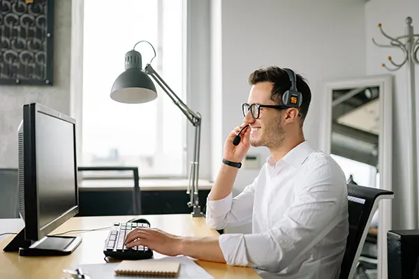 Man with white shirt talking to someone on headset