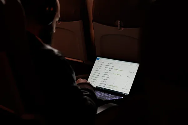 Man looking down at laptop in airplane
