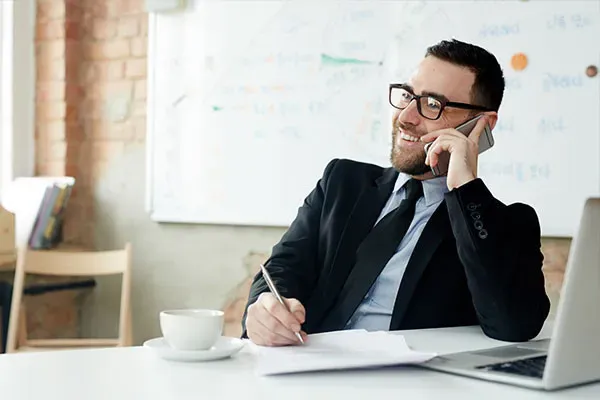 Cloud hosted phone system call recording Man writing while on a Cloud phone call in the office