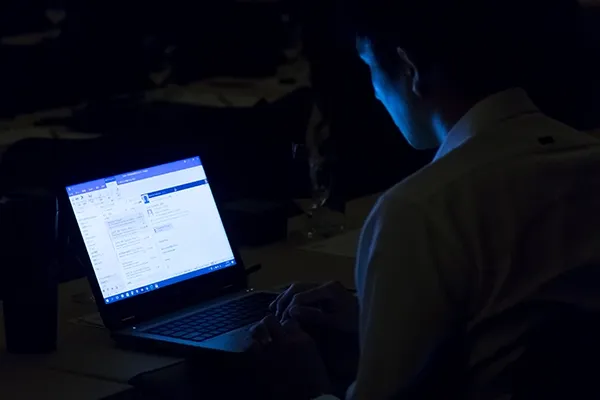 Person looking at laptop in a dark room