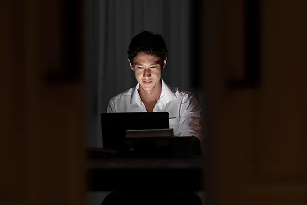 Man looking at laptop in the dark