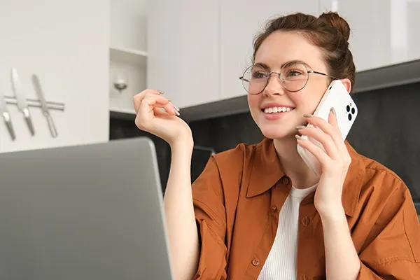 Woman with glasses holding phone up to left ear