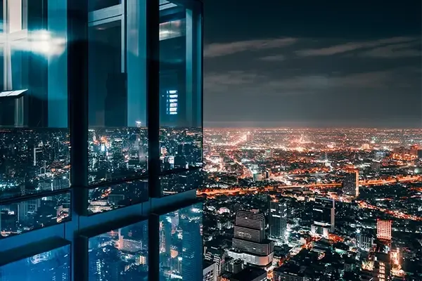 Glass people towering above city at dark