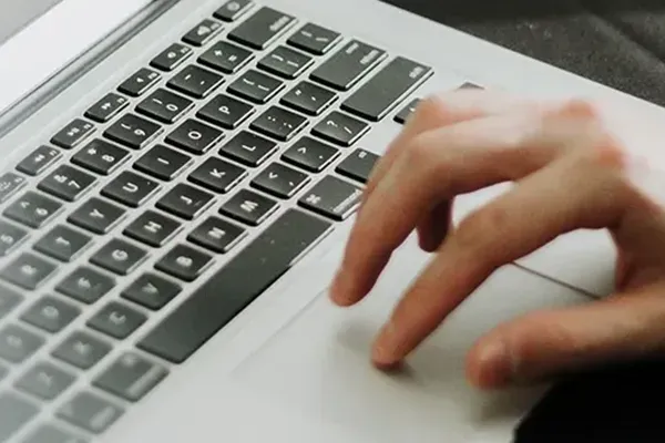 Close up of person using trackpad on laptop