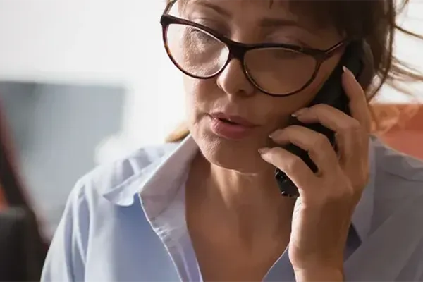 Woman with glasses talking to someone on mobile phone
