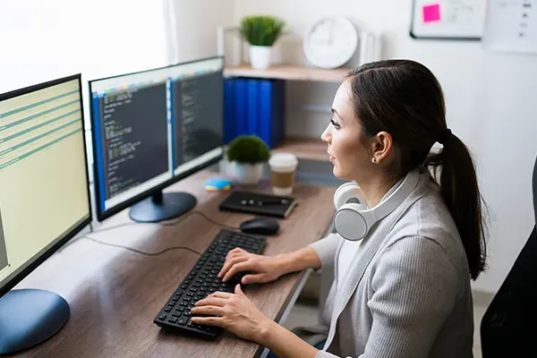 Woman looking at monitor while typing