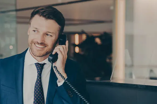 Business man making a phone call on a desk phone