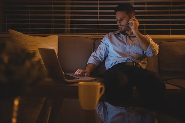 Man sitting down on a phone call while on laptop