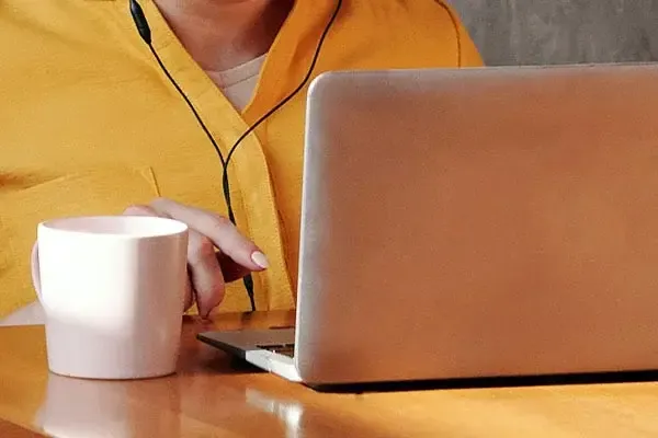 Woman in a yellow shirt using Microsoft teams calling on a Mac