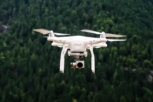 DJI drone flying in the air above forest