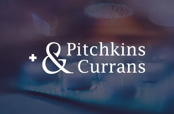 Pitchkins & Currans logo over blurred shot of tablets