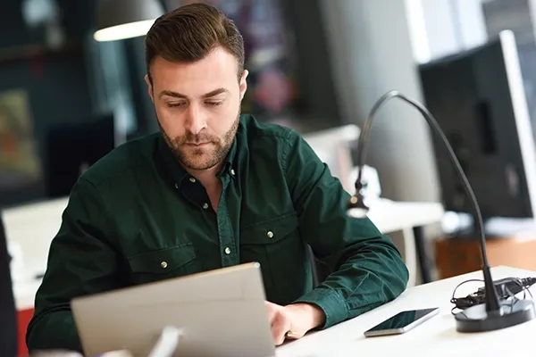 Man looking down at laptop while typing on it