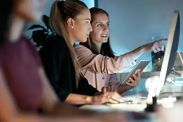 Woman pointing at other woman's monitor