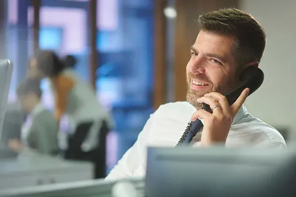 Man using Mitel on premise phone system in office