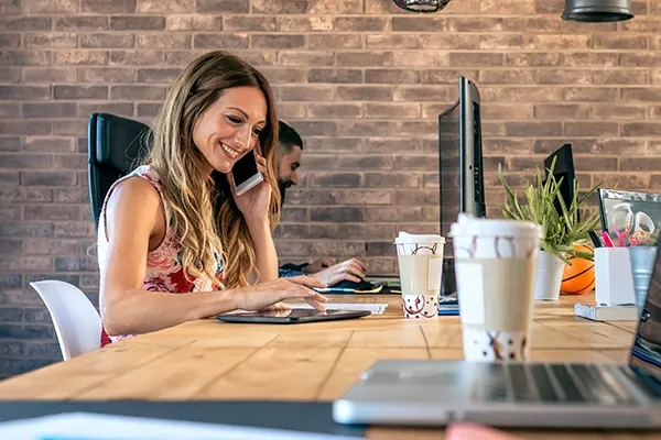 Woman holding phone up to left ear while typing