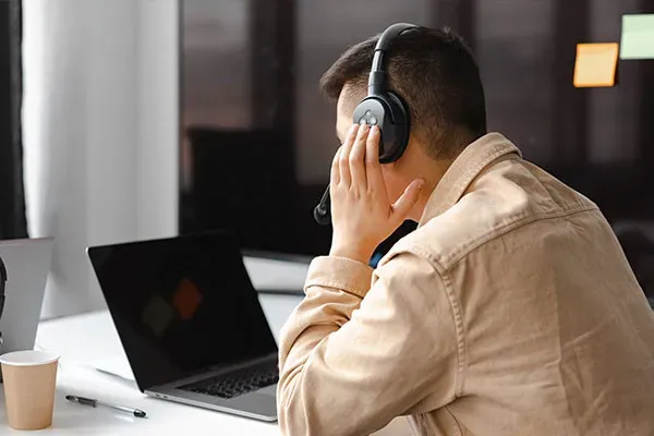 Man listening to cloud phone calls through headphone