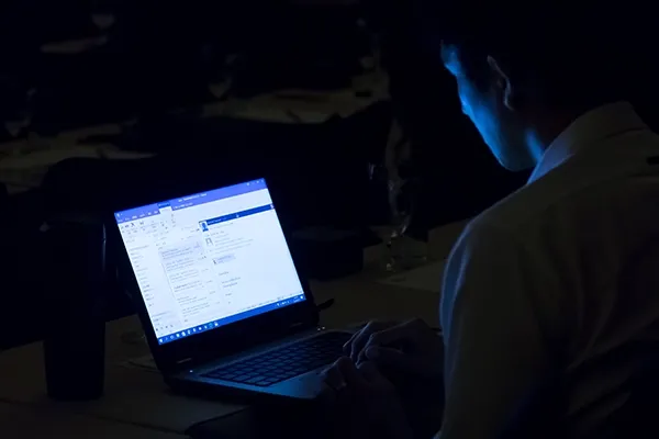 Person looking at laptop in a dark room