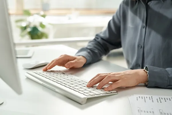 Person typing on computer keyboard in an office
