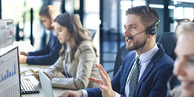 Man talking in call centre with headset on