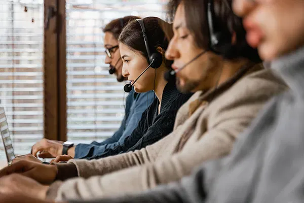 Four people in line talking with headsets on