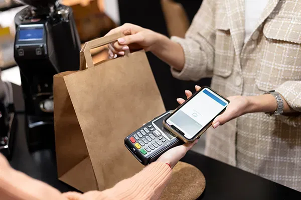 Person taking contactless payment in shop