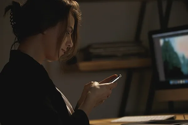 Woman looking down and typing on mobile phone