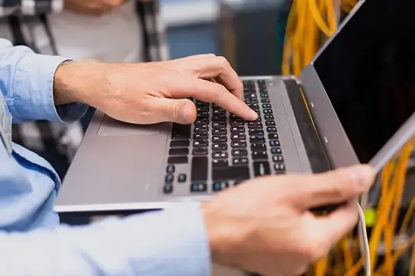 Person typing on laptop while standing