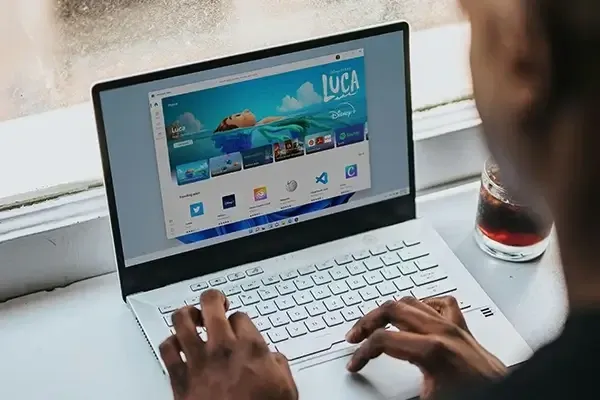 Person using laptop with Windows store open