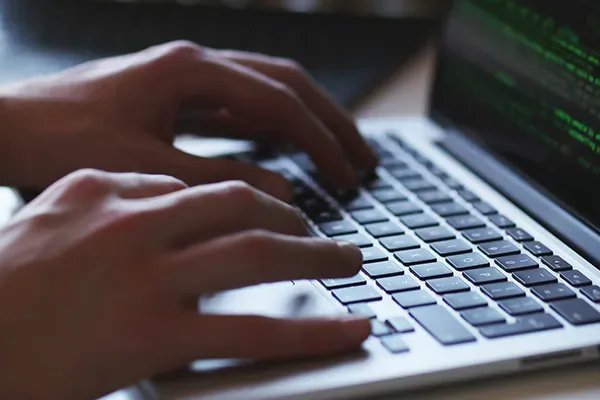 Close up of persons hands while typing on laptop