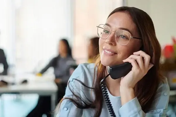 Woman using a handset to make a call using the Horizon VoIP phone system