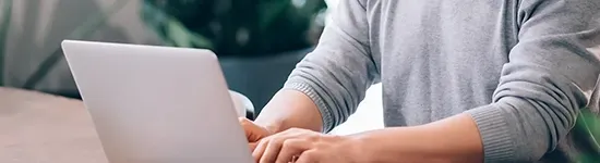 Person typing on laptop in well lit room