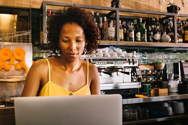 Woman in cafe looking down at laptop