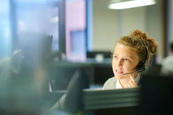Woman in office using a headset with the Horizon VoIP business phone
