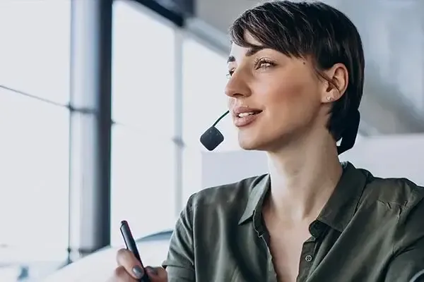 Woman using a VoIP phone system to make a call in the office