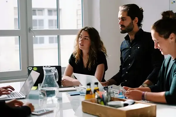 Group of people in a meeting room with laptops