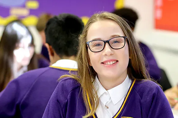Girl with glasses smiling at camera