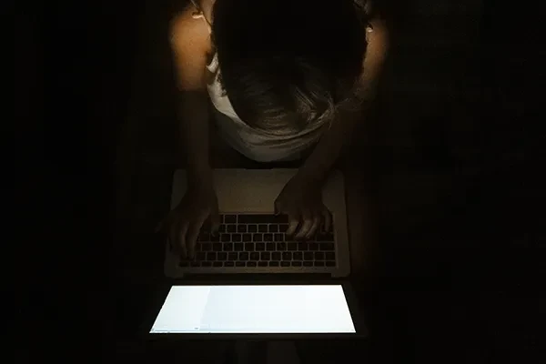 Person typing with laptop on their knees