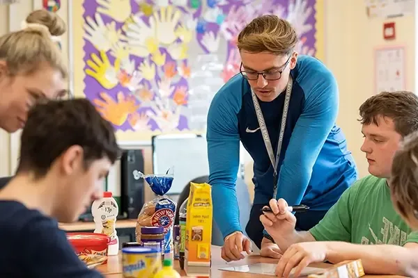 Teacher speaking to a group of students around a table